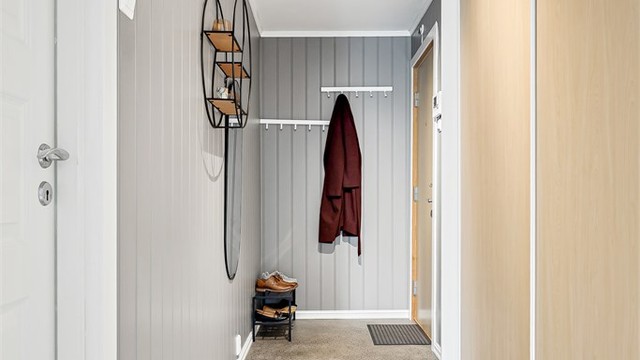 Skyvedørsgarderobe i entréen med plass til å henge fra seg.