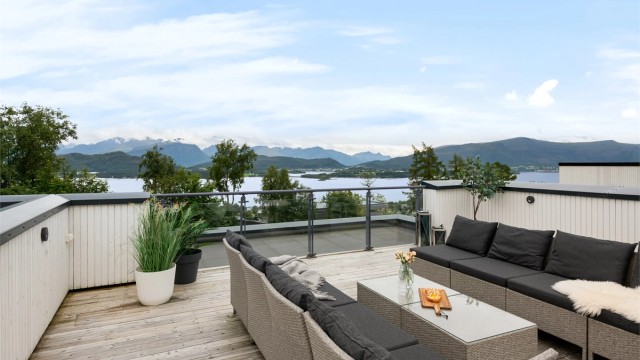 Fra takterrassen er det en vidstrakt utsikt over fjorden og fjellene.
