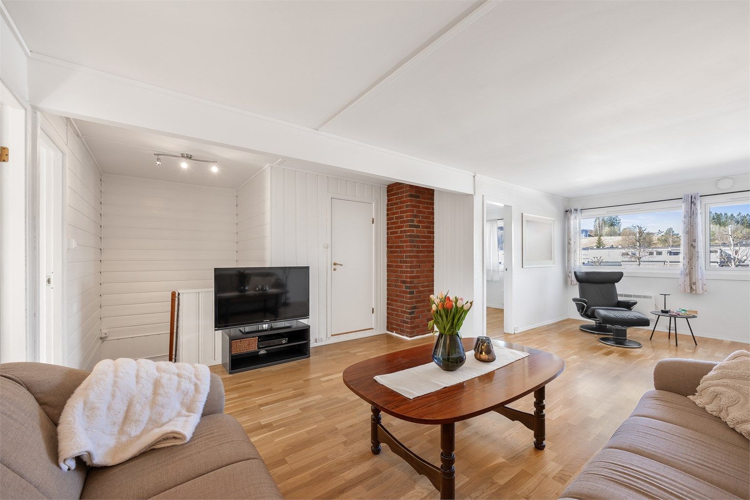 En teglsteinsdetalj gir stuen et rustikt og lunt preg.