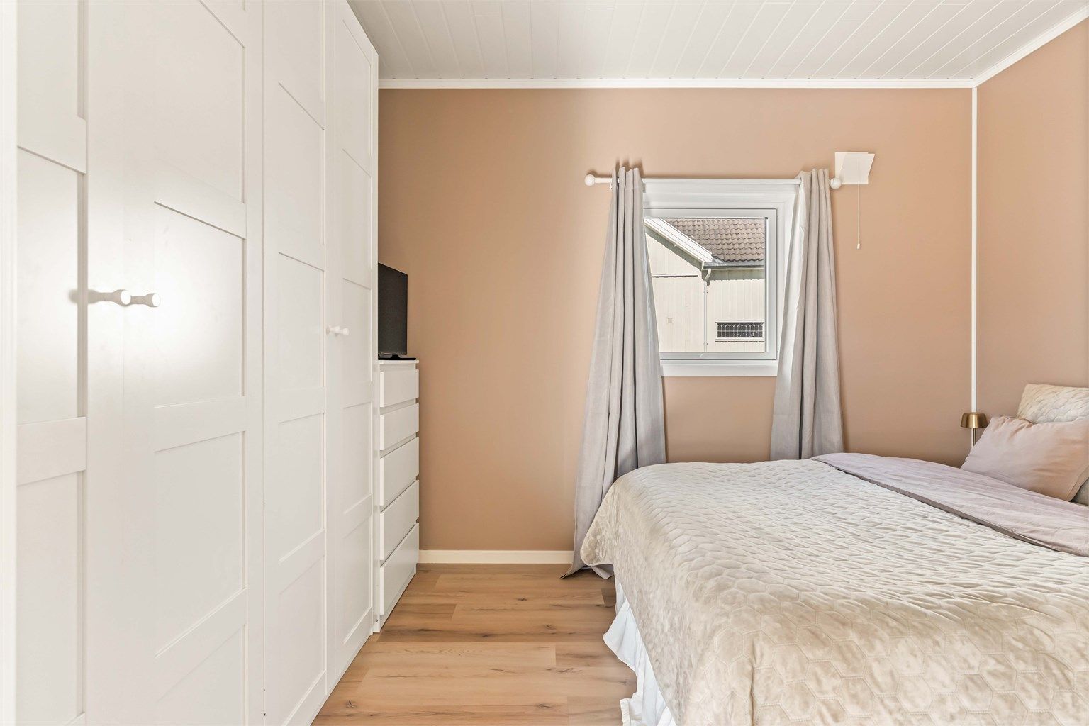 God plass til en stor garderobe og nattbord på begge sider av dobbeltseng.