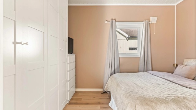 God plass til en stor garderobe og nattbord på begge sider av dobbeltseng.