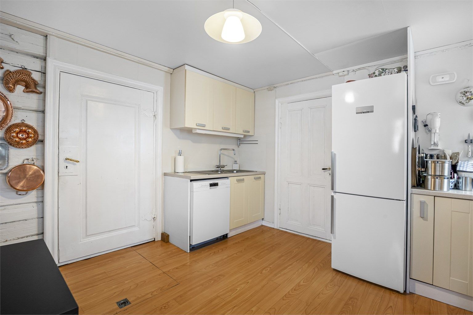 God skap- og benkeplass gir praktiske arbeidsforhold. Fra kjøkkenet er det adkomst til en råkjeller via luke i gulvet.