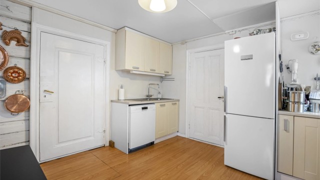 God skap- og benkeplass gir praktiske arbeidsforhold. Fra kjøkkenet er det adkomst til en råkjeller via luke i gulvet.