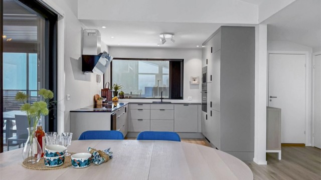 Lekkert, påkostet kjøkken med benkeplate i sort kvarts/kompositt, vinskap, integrert kaffemaskin og ellers full pakke med hvitevarer (Bosch).