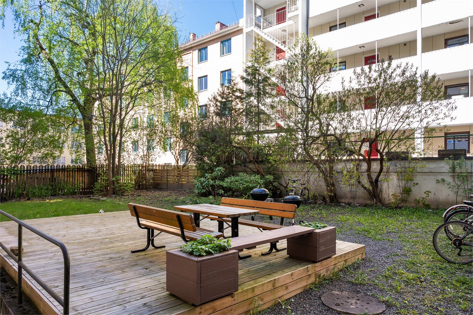 Bakgården er opparbeidet med blant annet sykkelparkering, blomsterkasser, sittegrupper, plenarealer og andre forskjellige beplantninger.