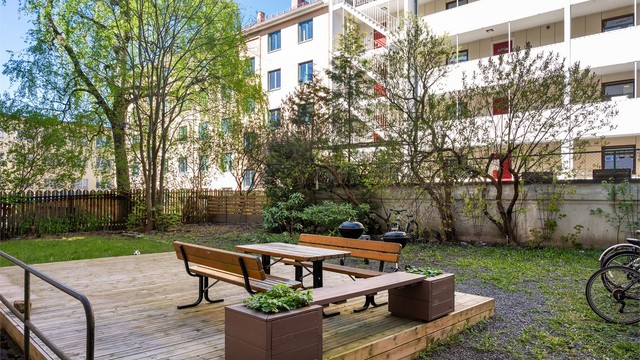 Bakgården er opparbeidet med blant annet sykkelparkering, blomsterkasser, sittegrupper, plenarealer og andre forskjellige beplantninger.