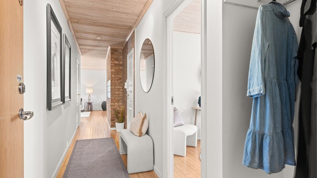 Entré/gang med nisje til yttertøy og originale tregulv. Begge soverommene og badet har praktisk adkomst fra gangen, samt at gangen også leder ut i stuen/spisestuen