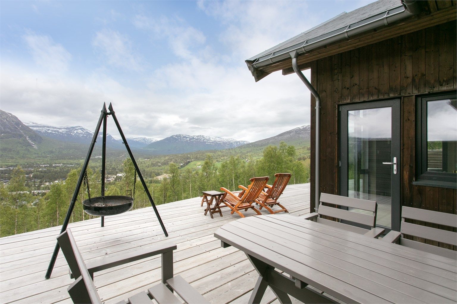 Terrassen har god plass til utemøbler og bålpanne, med vidstrakt utsikt mot fjellene.