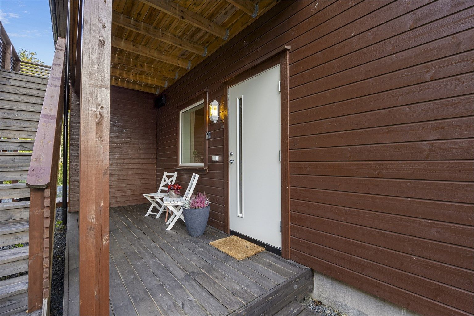 Inngangspartiet er overbygd og består av en liten terrasse. 