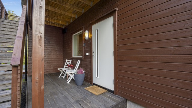 Inngangspartiet er overbygd og består av en liten terrasse.