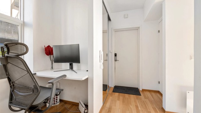 Entréen har god og plassbesparende garderobeløsning i skyvedørsgarderobe med speilfronter. Praktisk innhuk med plass til kontorløsning
