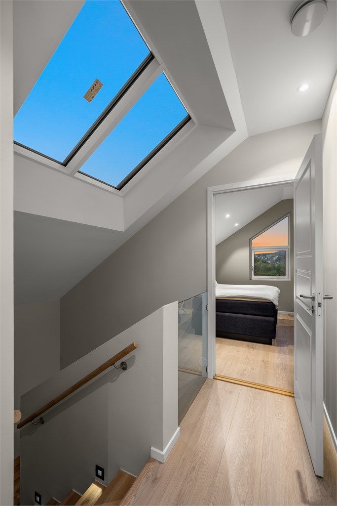 Trapperommet i tredje etasje har rekkverk i glass og Velux takvindu som tilfører rikelig med dagslys.