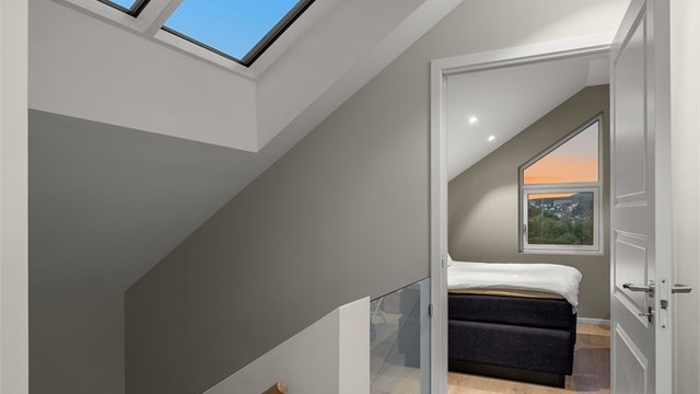 Trapperommet i tredje etasje har rekkverk i glass og Velux takvindu som tilfører rikelig med dagslys.