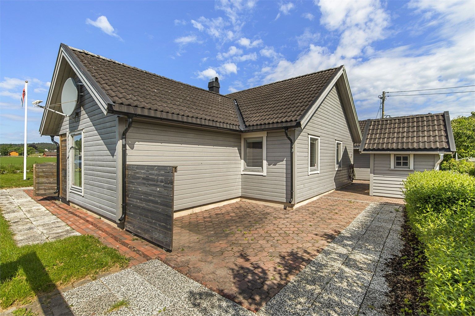 På baksiden av huset er det en østvendt, steinbelagt uteplass.