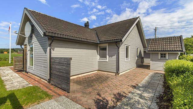 På baksiden av huset er det en østvendt, steinbelagt uteplass.