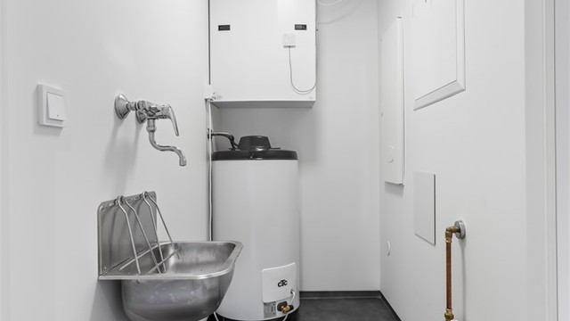 Praktisk teknisk rom med opplegg for vaskemaskin og plass til oppbevaring.