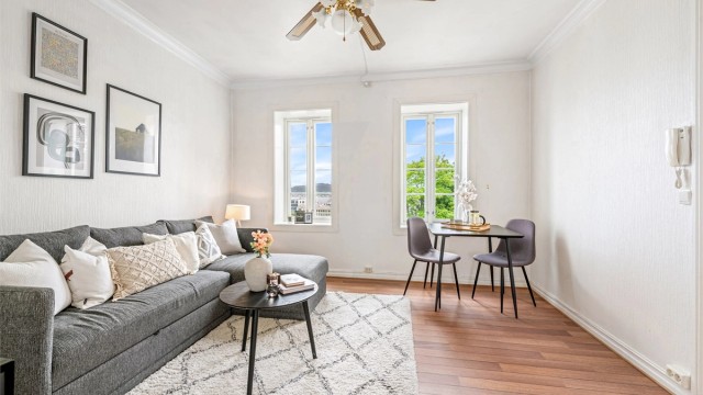 Stuen har plass til både sofagruppe og spiseplass. Gulvene har parkett, og veggene har malte, tapetserte flater.
