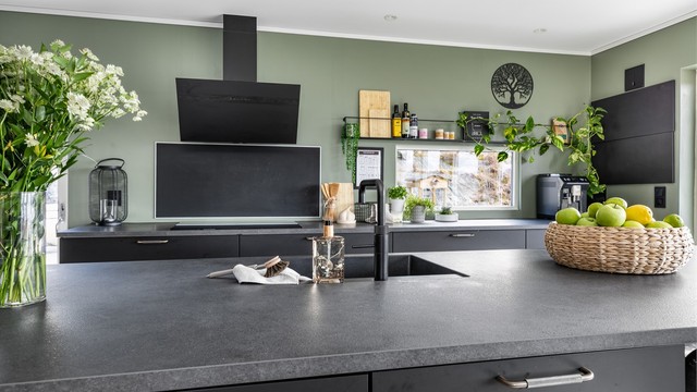 Store arbeidsflater og mange lett tilgjengelige oppbevaringsmuligheter gjør kjøkkenet meget praktisk. Rundt øyens barløsning er det sitteplass for fire-seks personer.