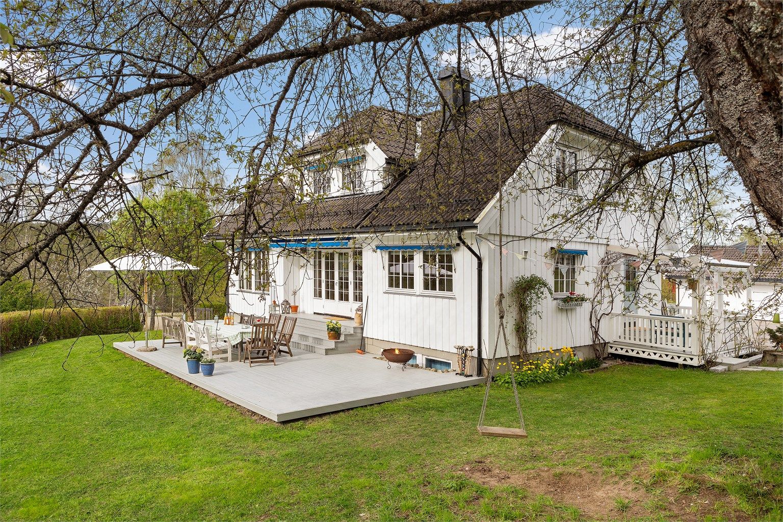 Stor vestvendt terrasse og gressplen 