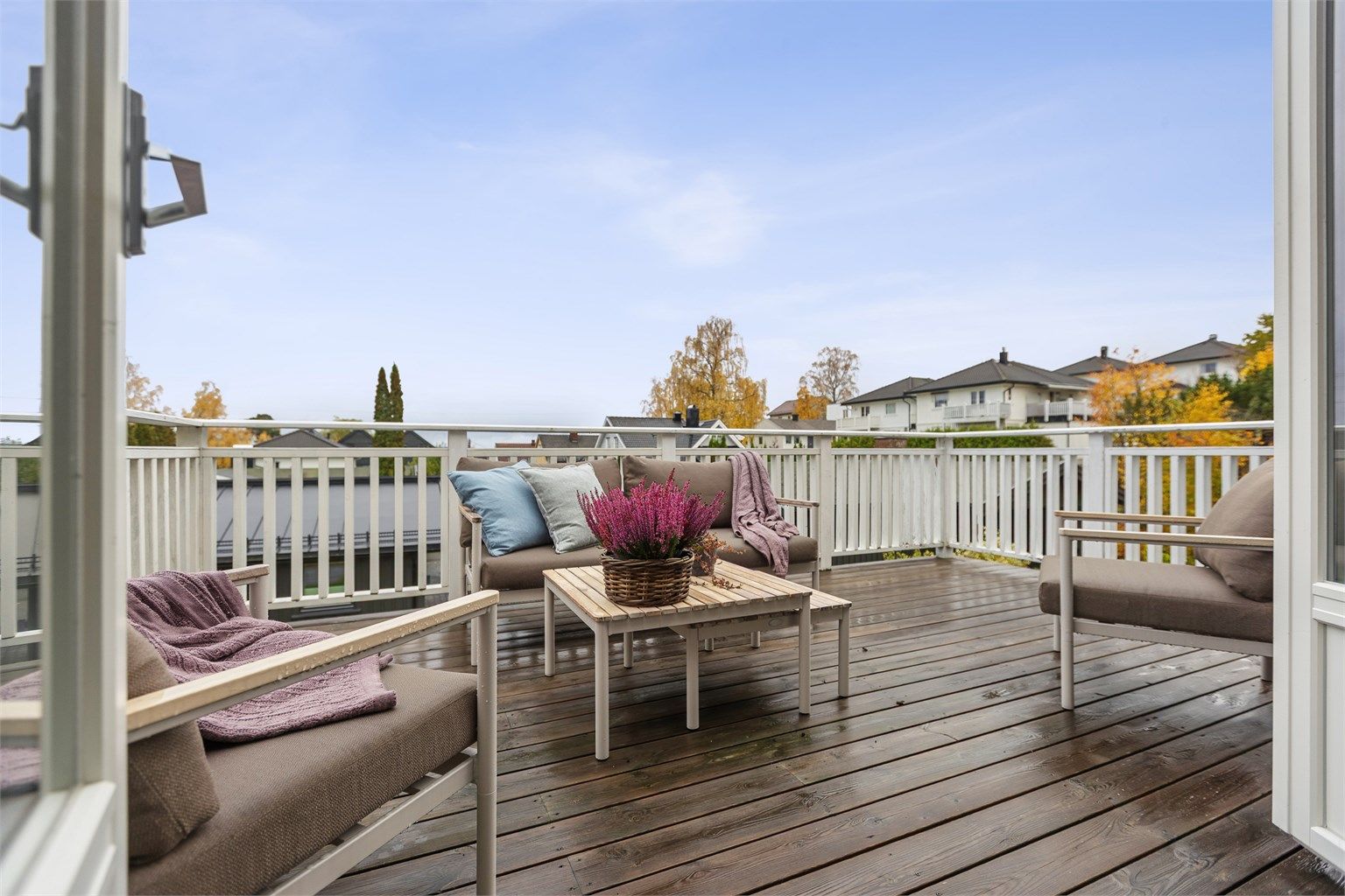 Terrassen er belagt med impregnerte terrassebord og hvitt rekkverk.