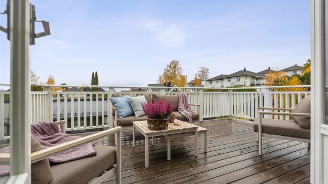Terrassen er belagt med impregnerte terrassebord og hvitt rekkverk.