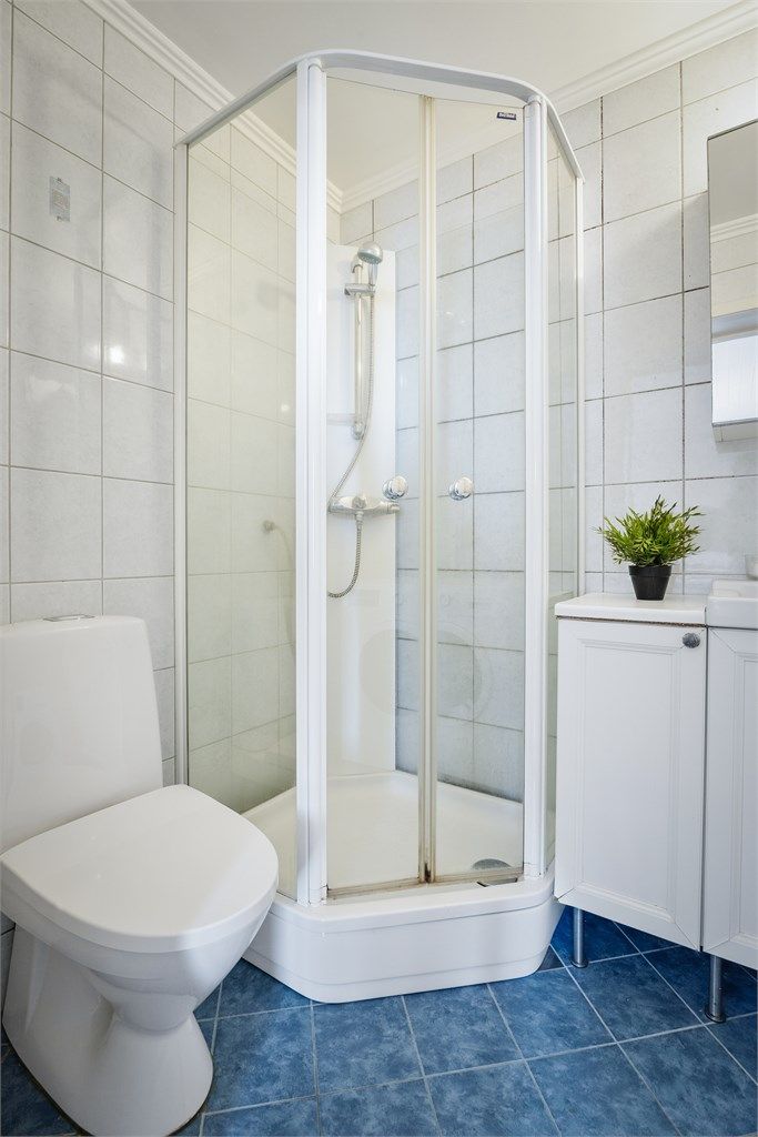 Badet er innredet med gulvstående servantinnredning, speilskap, gulvstående høyskap, dusjkabinett, gulvstående toalett og opplegg for vaskemaskin