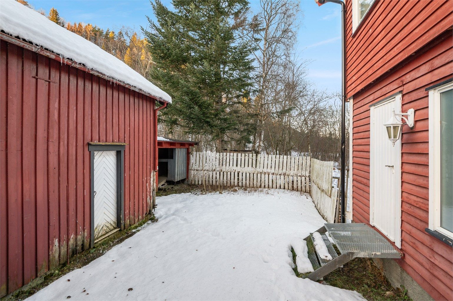 Bildet viser vaskeromsinngangen og deler av utendørsarealet mot garasje/bod. 