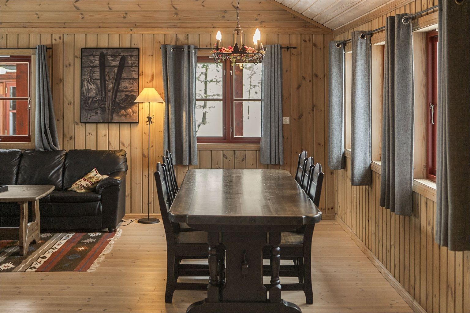 Store vindusflater slipper inn dagslys og rammer inn naturen utenfor.