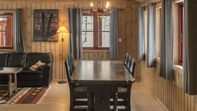 Store vindusflater slipper inn dagslys og rammer inn naturen utenfor.