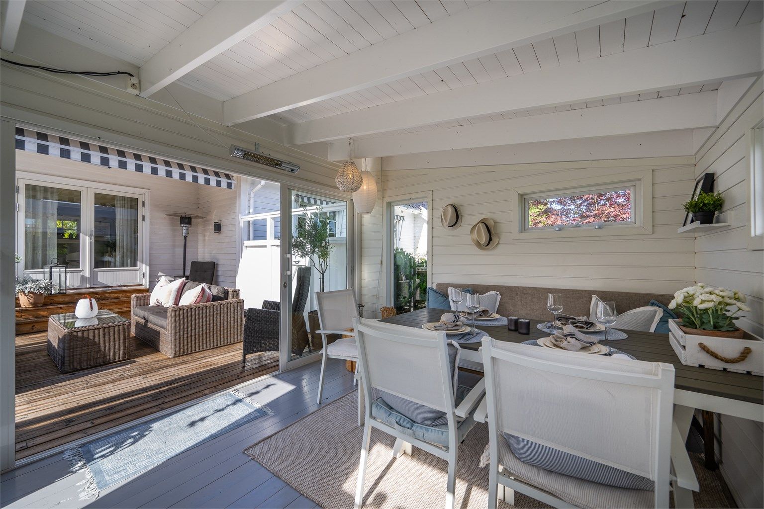 Skyvedører i glass åpner utestuen direkte opp mot treterrassen.