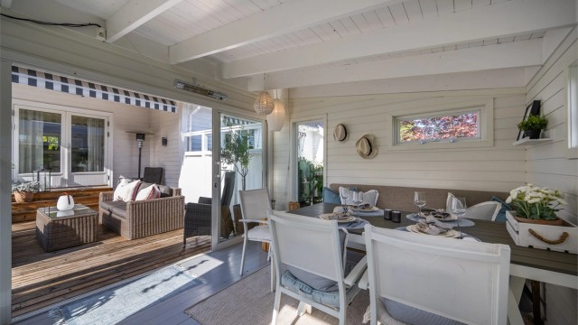 Skyvedører i glass åpner utestuen direkte opp mot treterrassen.