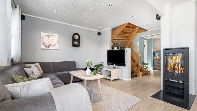 Stuen har også plass til koselig sofakrok med innsyn til flammene i den stilige peisovnen fra Jøtul