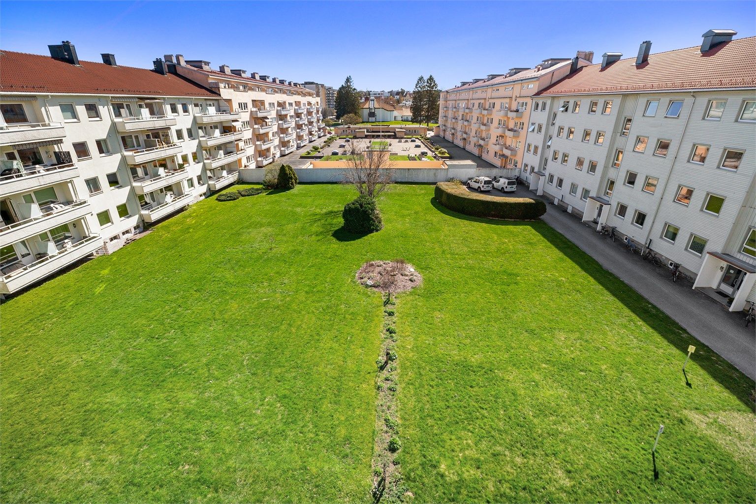 Utsikt fra balkong over flott felles bakgård tilhørende borettslaget