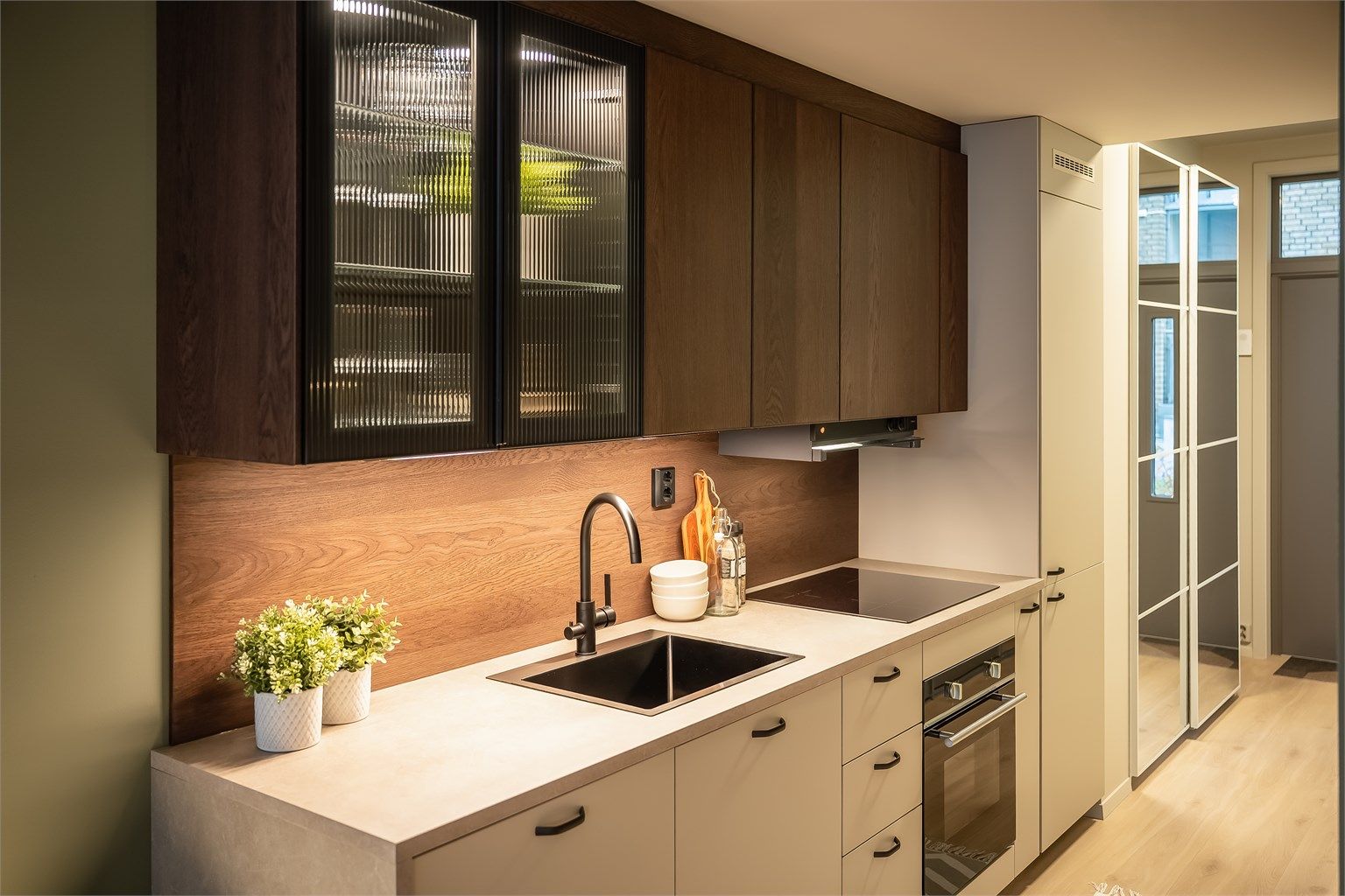 Kjøkkeninnredningen har også et vitrineskap med integrert belysning og glassdører