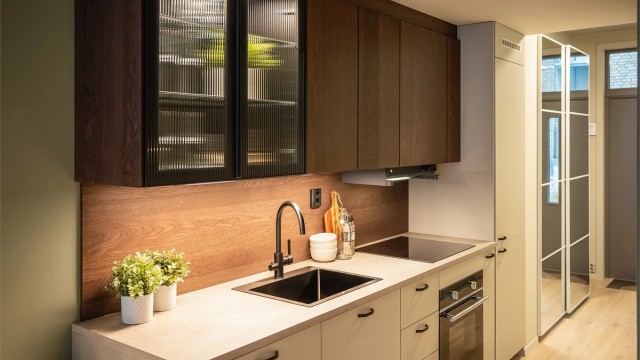 Kjøkkeninnredningen har også et vitrineskap med integrert belysning og glassdører