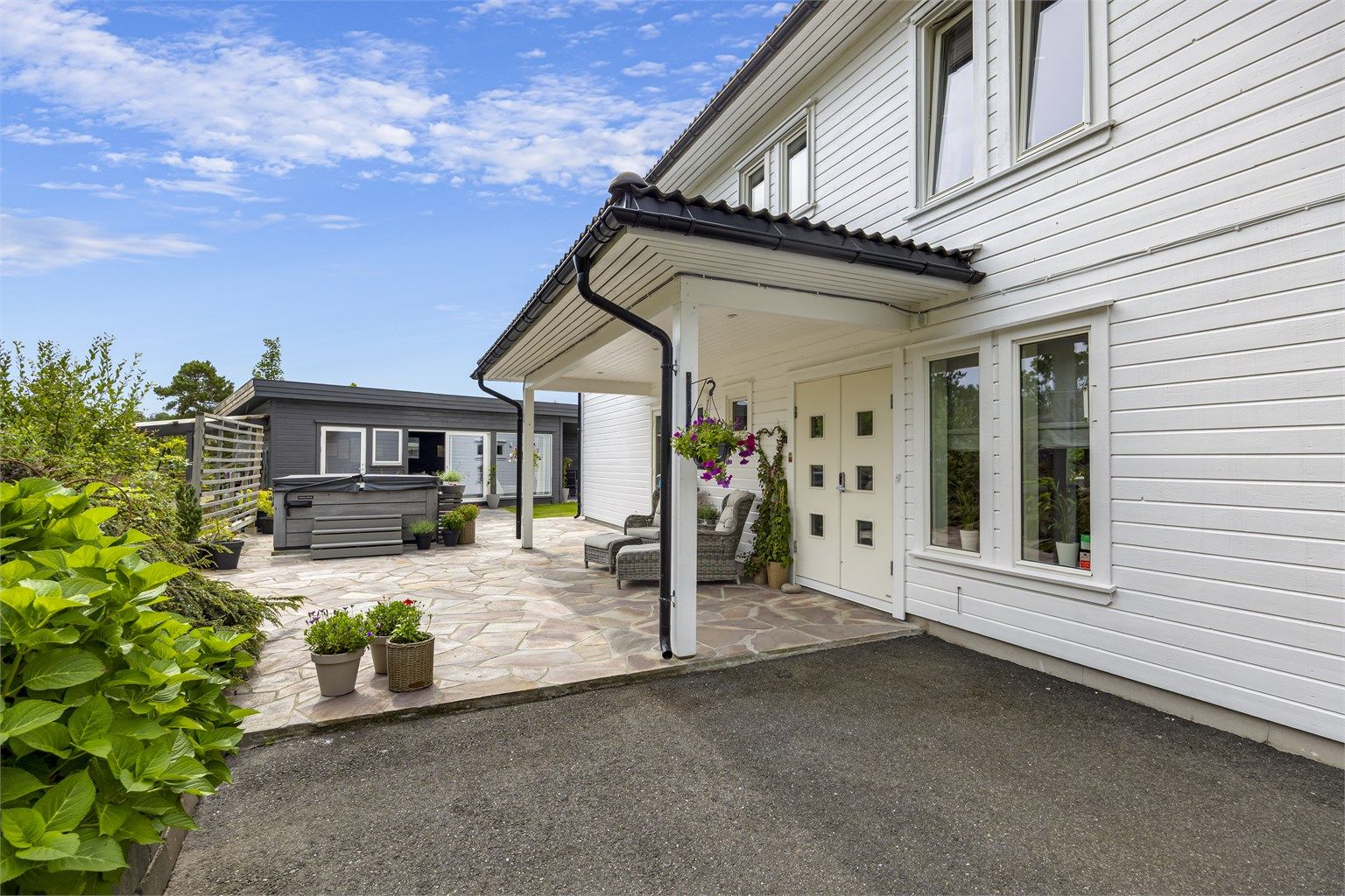 Inngangspartiet er overbygd og en dobbeldør ønsker velkommen inn i boligen. 
