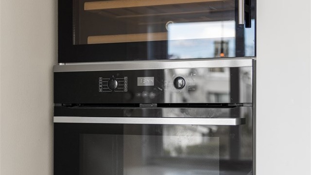 Høyskap med integrert stekeovn og vinskap.