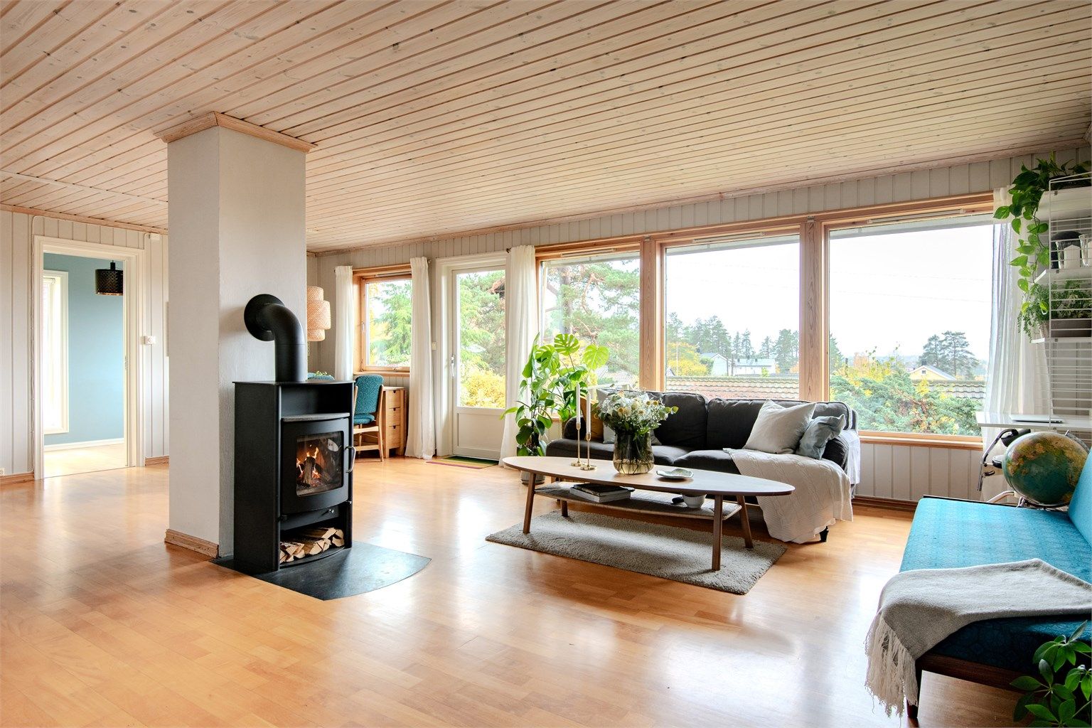 Stuen har en effektiv og varmende peisovn og store vindusflater med direkte utgang til uteplassen.