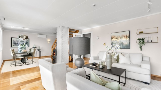Stuen er et samlingspunkt med parkett på gulvet og plass til flere sittegrupper.