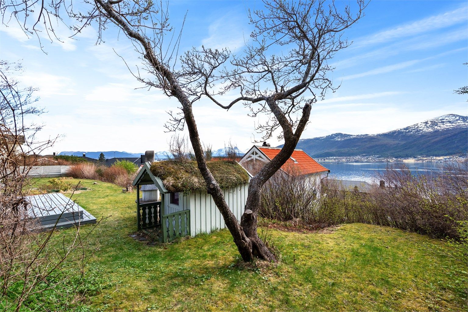 I hagen står et sjarmerende uthus på ca. 7 m² med torvtak. Foran uthuset er det en terrasseplatting på ca. 16 m².