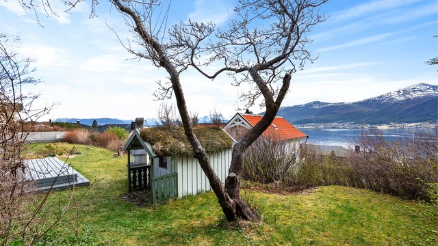I hagen står et sjarmerende uthus på ca. 7 m² med torvtak. Foran uthuset er det en terrasseplatting på ca. 16 m².