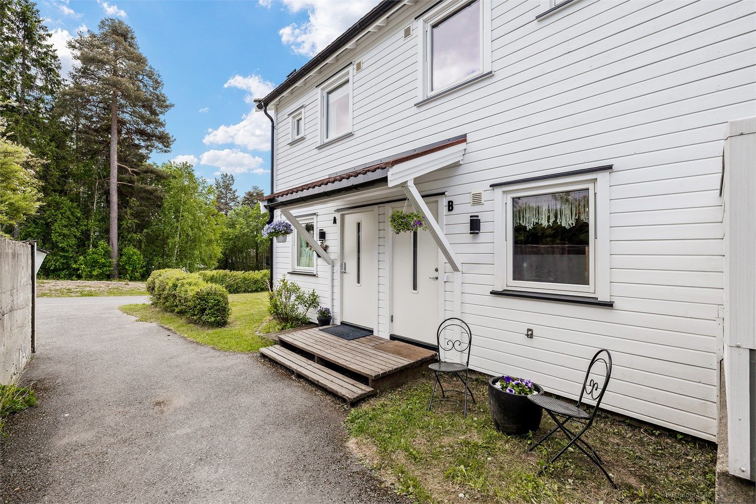 Overbygget inngangsparti med mulighet for sittegruppe utenfor kjøkkenvinduet.