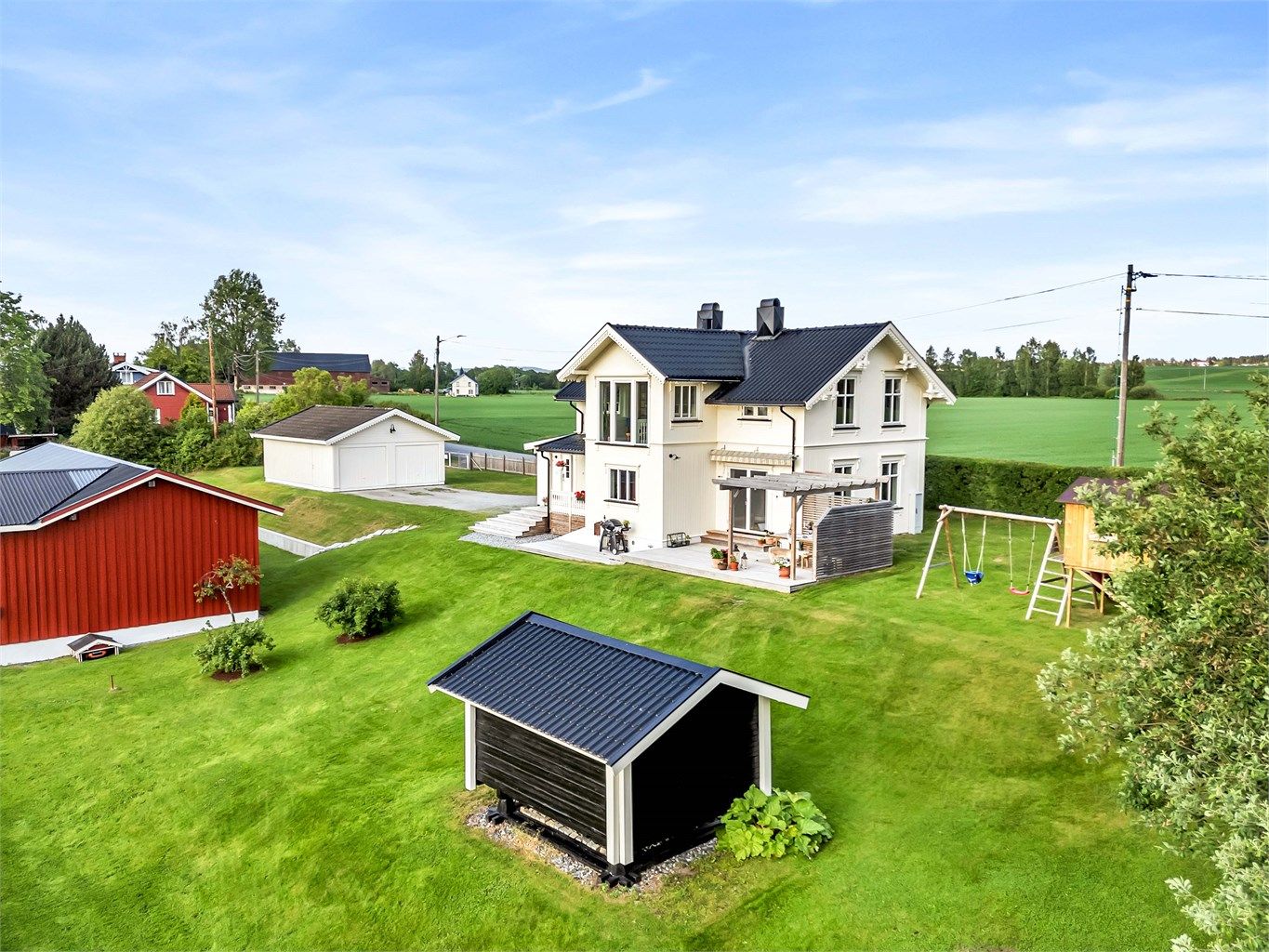 Uteområdet er pent opparbeidet med store plenarealer.