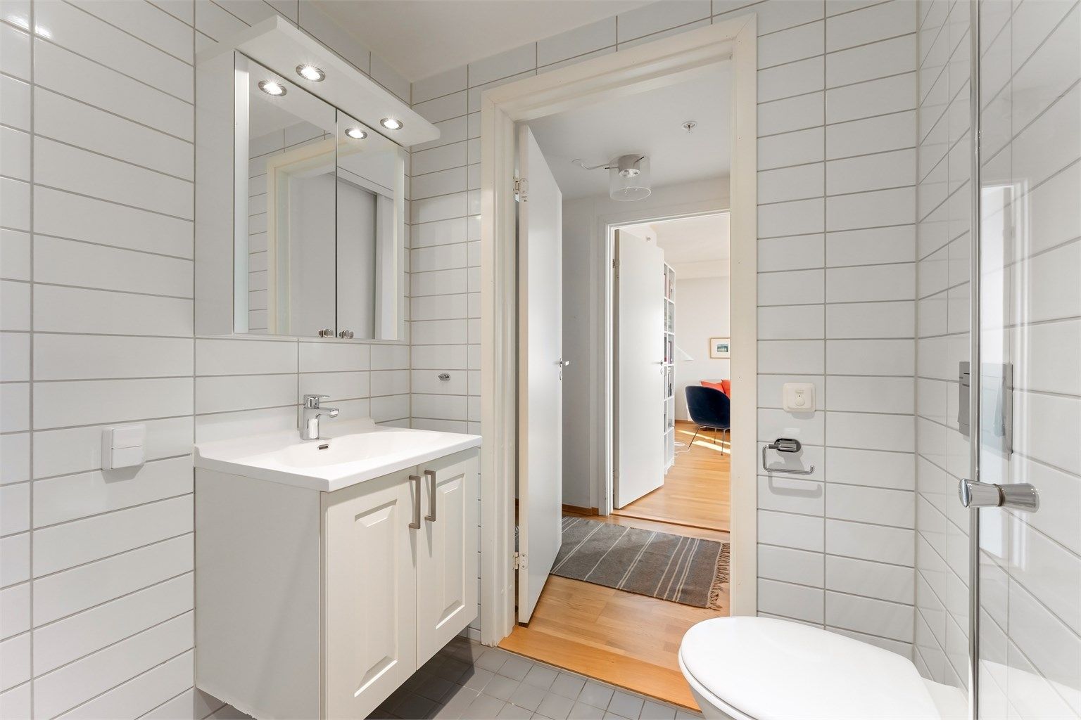 Innredningen består av et vegghengt servantskap og speilskap med belysning.