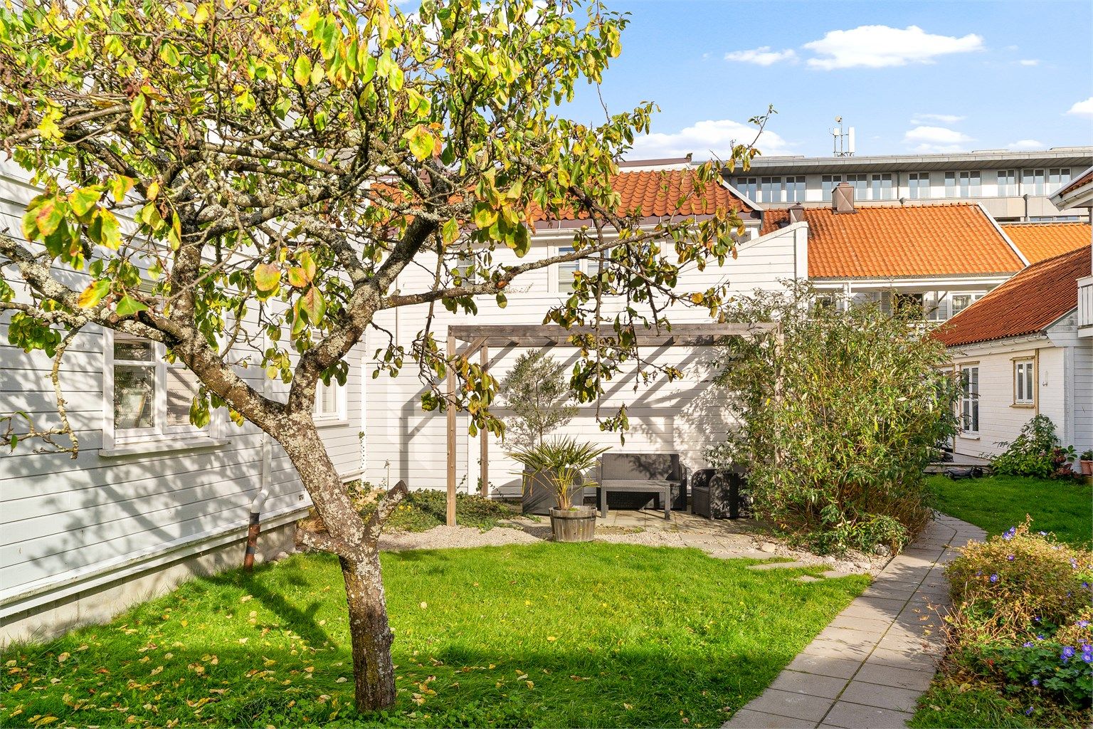 Felles koselig hage med hagemøbler og pergola. 