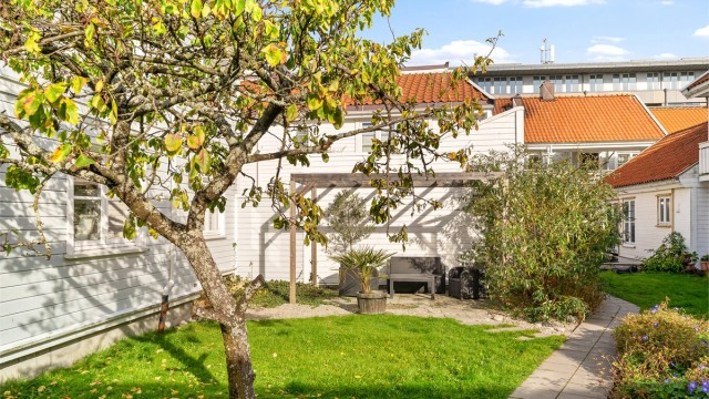 Felles koselig hage med hagemøbler og pergola.