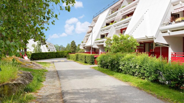 Sommerbilde ved inngangspartiet med pent opparbeidet uteareal