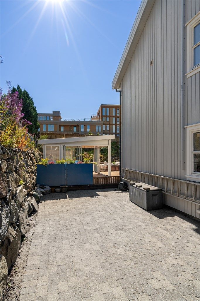 Belegningsstein ved siden av boligen og i gårdsrom.
