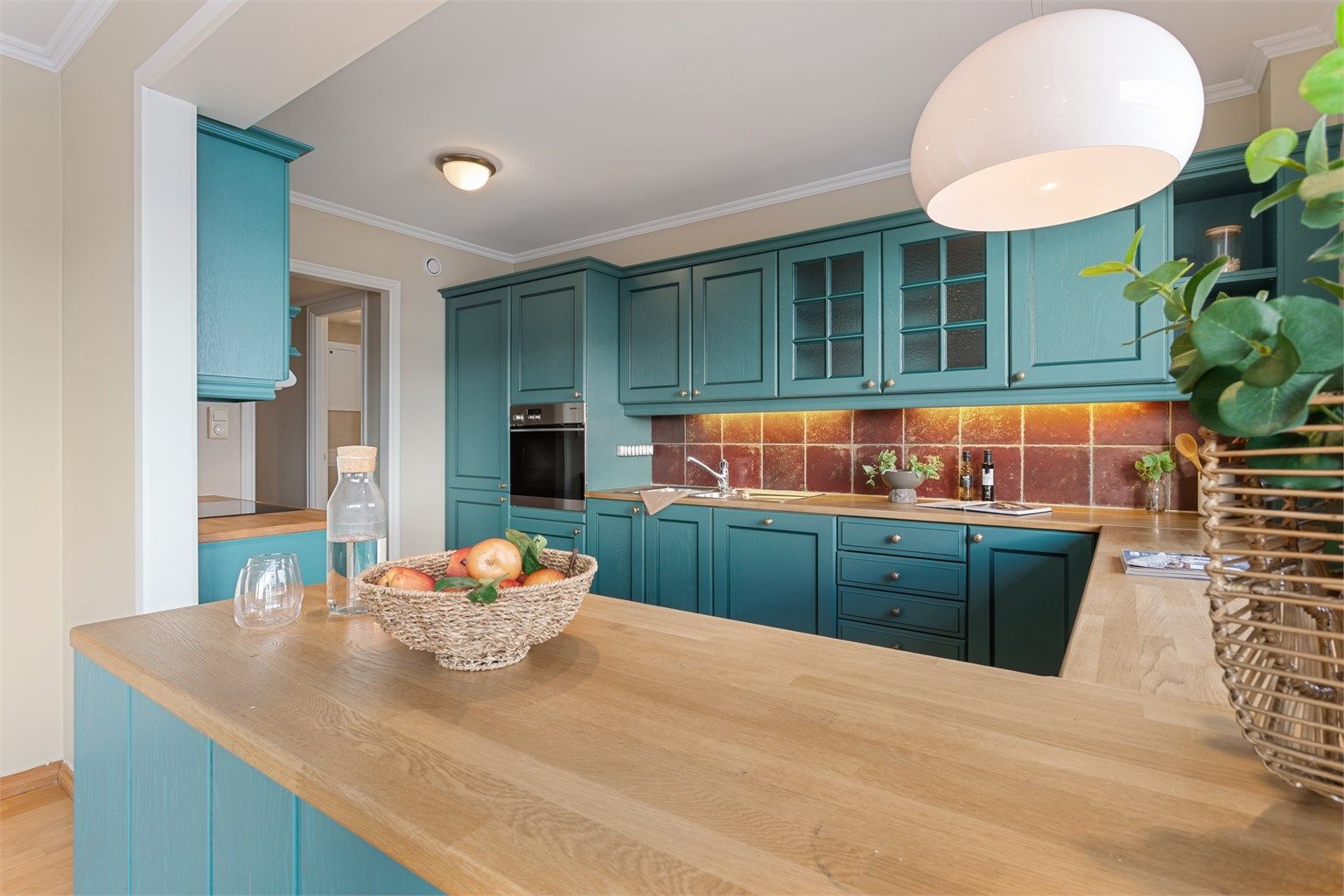 Kjøkken med innredning med profilerte fronter. Benkeplate av laminat med nedfelt oppvaskkum