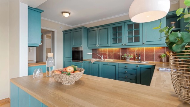 Kjøkken med innredning med profilerte fronter. Benkeplate av laminat med nedfelt oppvaskkum